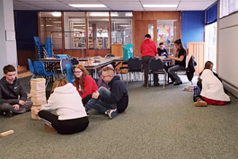 在蓝水的青少年家庭学校青少年合作社聚在一起在图书馆玩棋盘游戏。